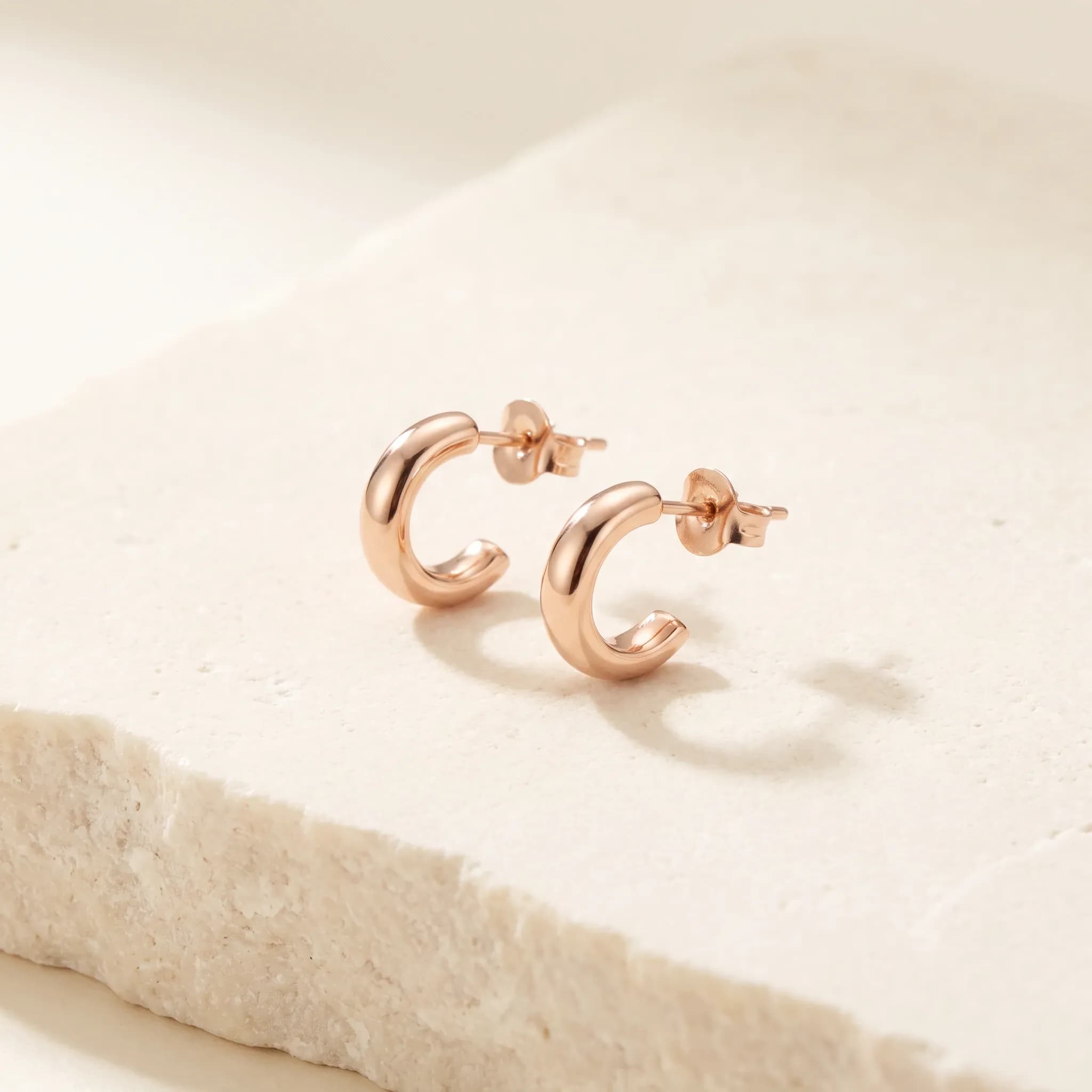 Arc Stud Earrings, an illustrative rose-gold tone jewelry concept